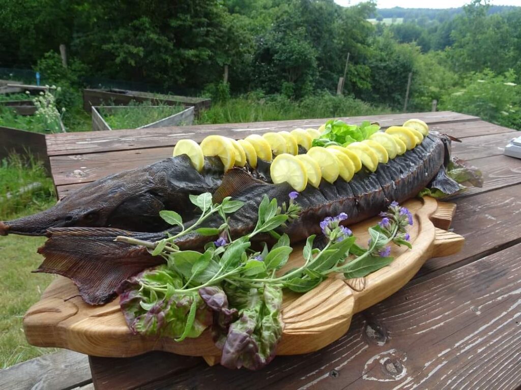 Wędzona ryba na desce udekorowana cytrynami